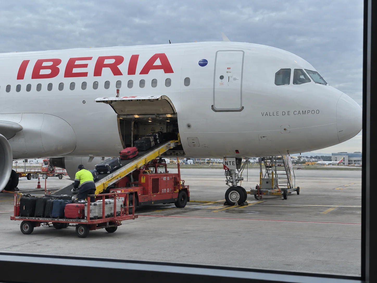 Fusoliera Iberia e carrello bagagli durante le operazioni a terra.