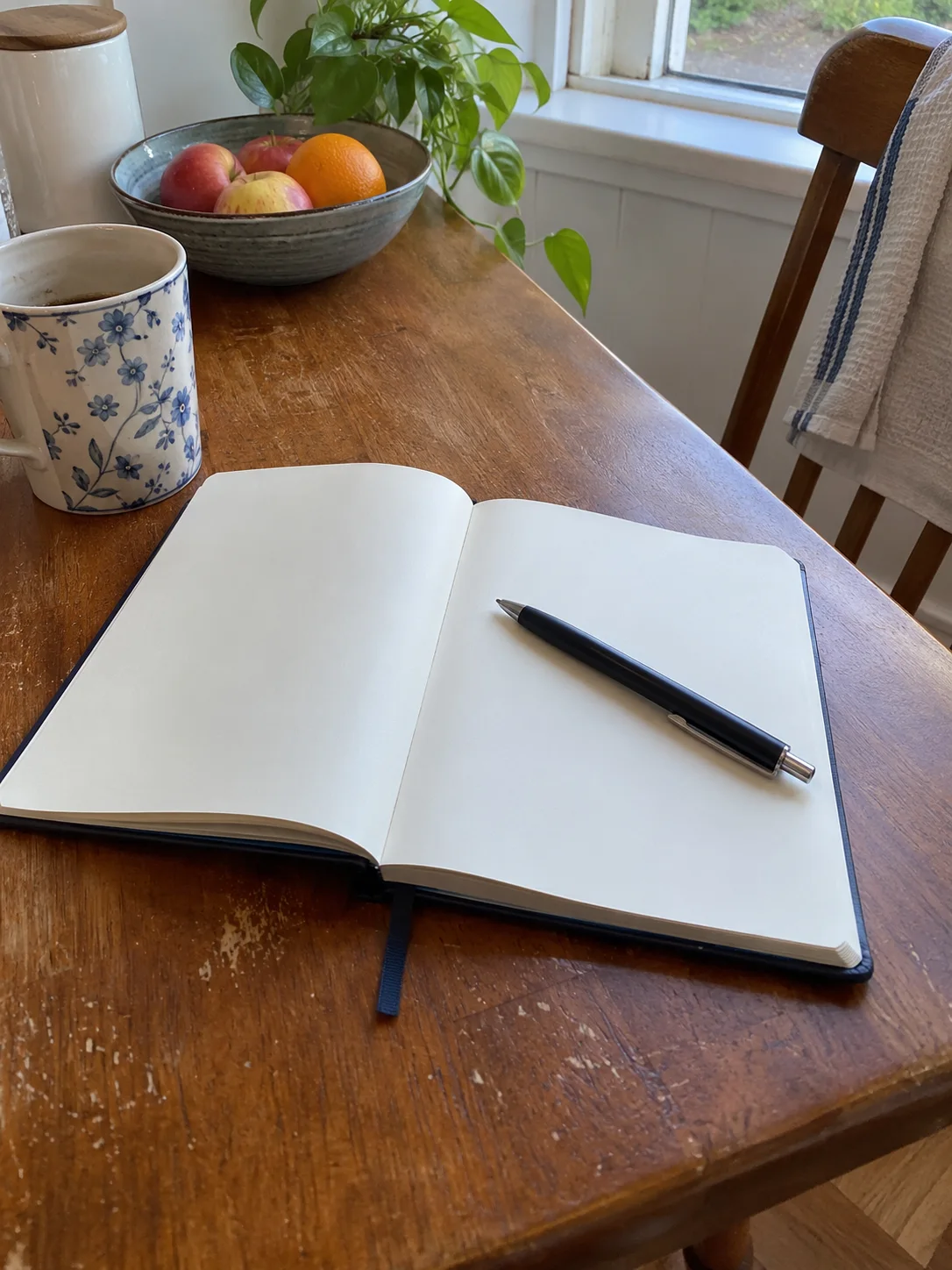Quaderno aperto e penna sul tavolo per organizzare le spese.